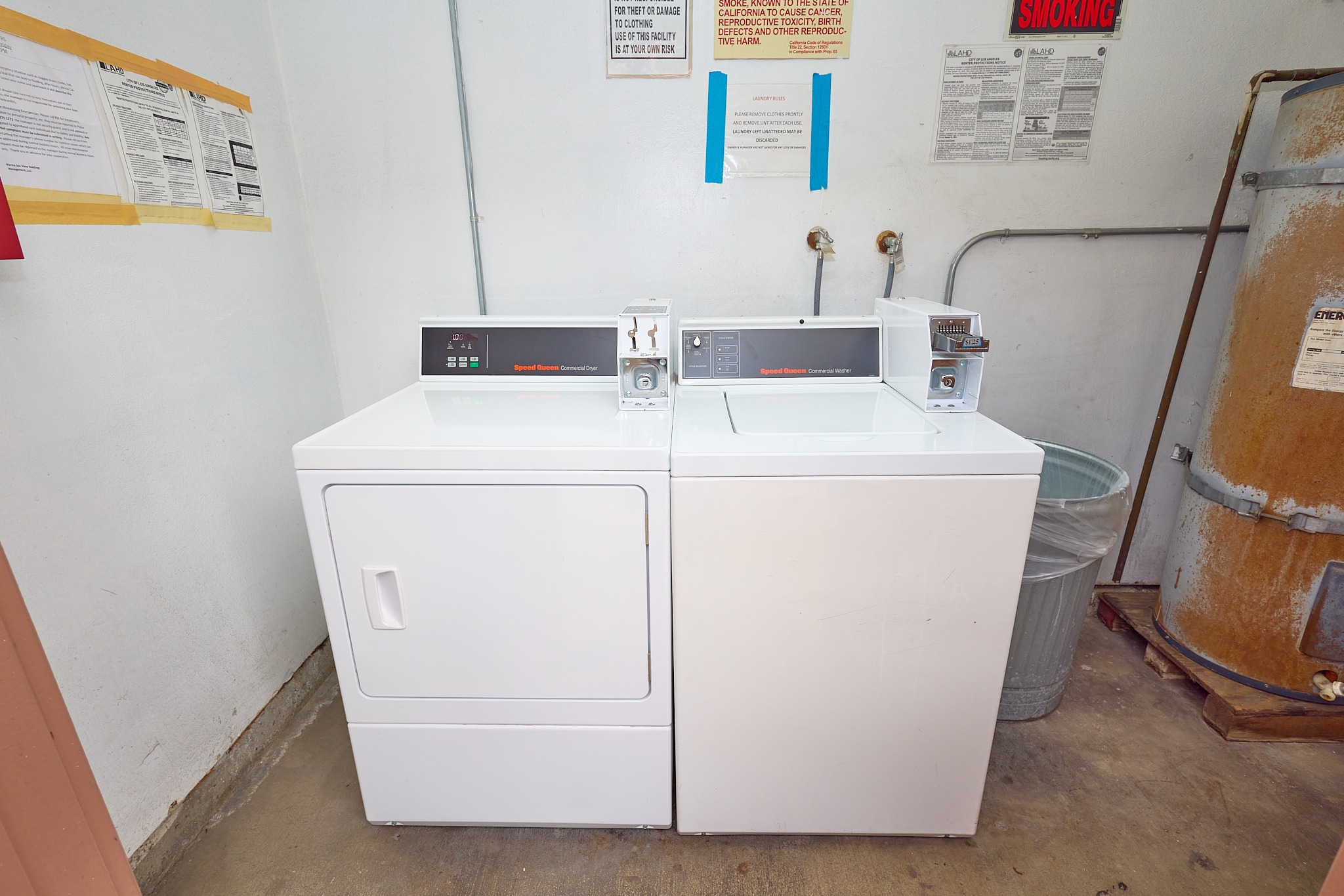 A white appliance with a black top sits in a room with a warning sign on the wall.